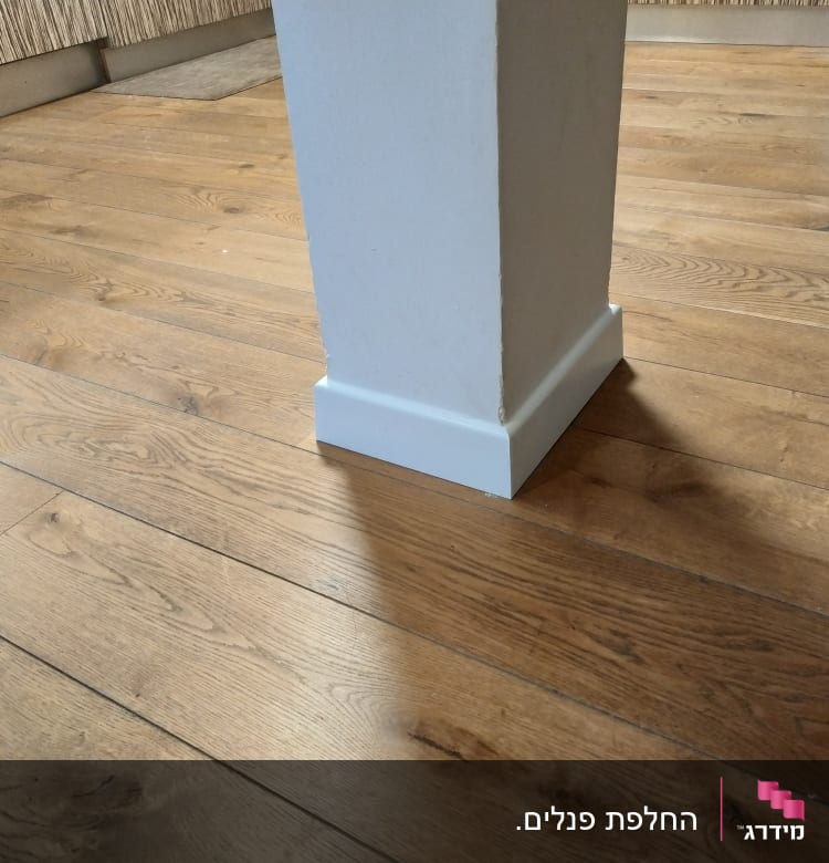 רצפת פרקט עץ עם עמוד לבן במרכז